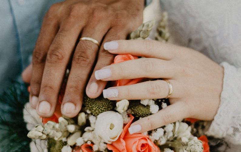 Man and Woman's Hands on Top of Ball Bouquet