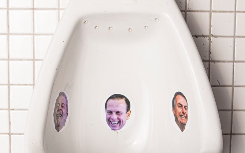 a urinal with a bunch of stickers on it