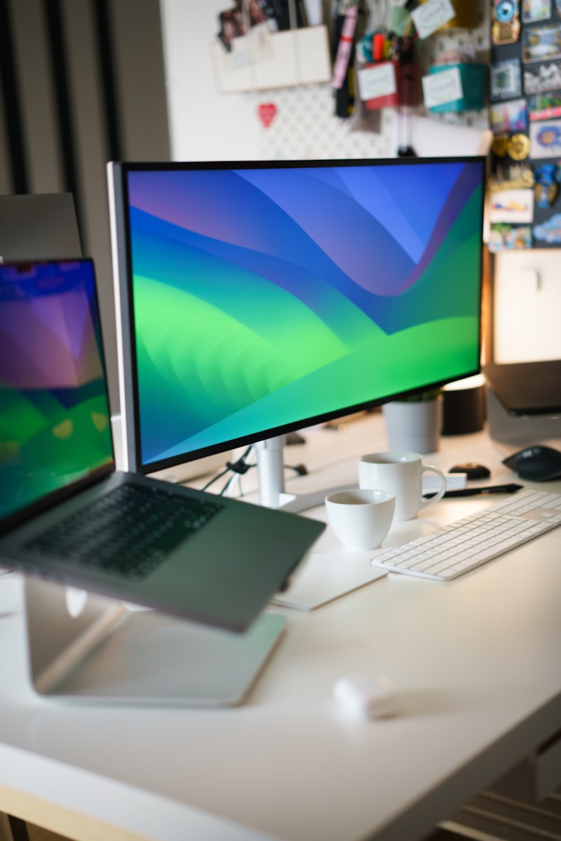 a desk with a laptop and a monitor on it